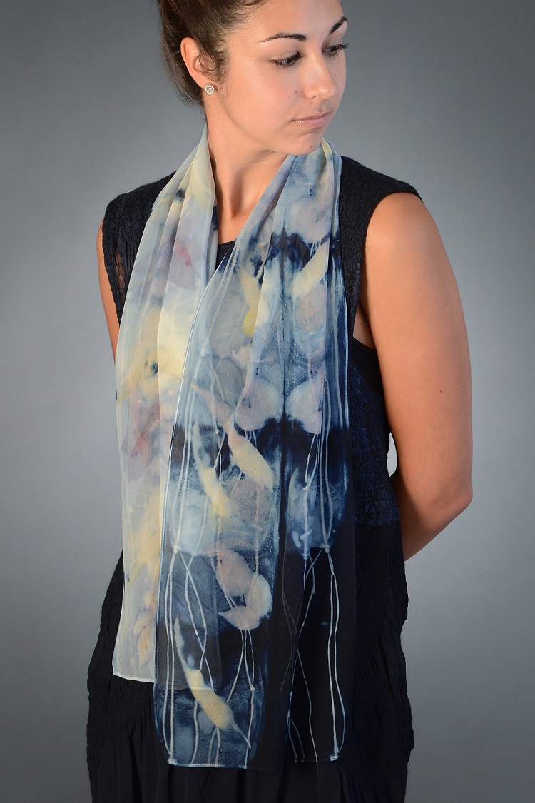 A woman poses in a silk scarf syed in different shades of blue.